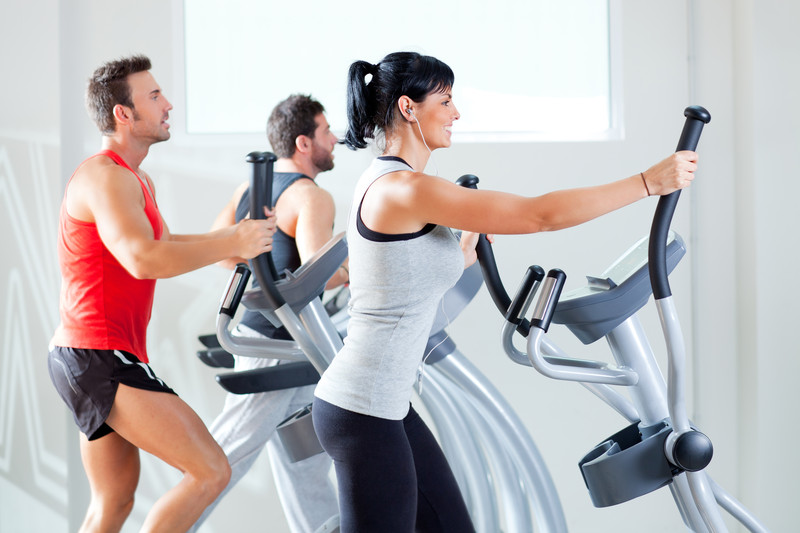 man and woman on elliptical trainers